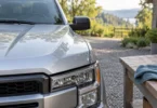 Close-up of a silver pickup hood beside a wooden workbench and blue cleaning cloth