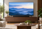 A black soundbar centered beneath a television on a wooden console in a bright living room