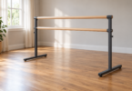 Generic double wooden ballet barre with dark metal uprights and T-shaped feet in an empty sunlit room
