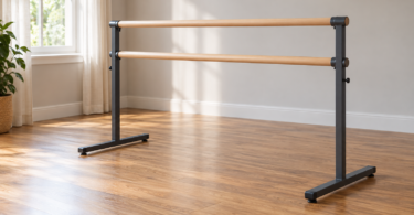 Generic double wooden ballet barre with dark metal uprights and T-shaped feet in an empty sunlit room