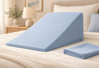 Illustration of a pale blue zippered cover on a triangular bed wedge with a folded spare cover on a bed