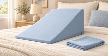 Illustration of a pale blue zippered cover on a triangular bed wedge with a folded spare cover on a bed