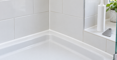 White tiled shower corner with a neat white joint beside a plain white cartridge and gray smoothing tool