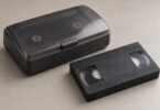 Generic full-size VHS cassette beside an unbranded tape rewinder
