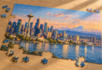 Partly assembled jigsaw with an illustrated Seattle skyline and loose pieces on a wooden table