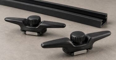 Two unbranded black bed rail cleats with thumbwheels beside a rail section