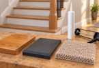 Wood, ribbed rubber and carpet stair-tread samples on a workbench beside an unbranded adhesive cartridge and caulking gun.