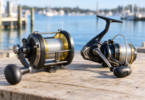 A generic conventional reel and spinning reel with wound line on a wooden surface beside a marina.