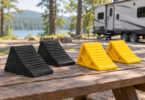 Conceptual image of black rubber and yellow plastic wheel chocks on a picnic table near a parked RV.