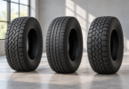 Three unbranded black tires with different tread patterns standing on a light gray floor