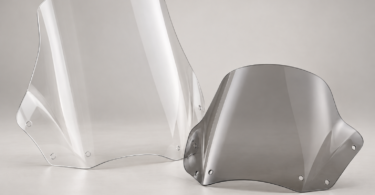 Two unbranded touring motorcycle windshields, one tall and clear and one shorter with a light gray tint, on a neutral studio background