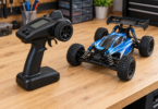 Black pistol-grip radio transmitter beside a blue RC off-road buggy on a wooden hobby workbench