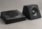 Generic low-profile black subwoofer enclosure beside a charcoal wedge-shaped subwoofer box
