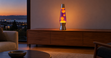 A tall unbranded lava-style lamp with amber wax and violet liquid on a clear wooden sideboard at dusk.