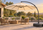 Conceptual illustration of a cream cantilever umbrella over patio seating, with an enclosed ballast base on level paving and an unbranded sand bag nearby.