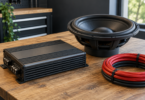 Generic disconnected car amplifier, subwoofer driver and coiled insulated power cable on a workbench
