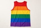 Illustration of rainbow-striped sleeveless athletic tank top laid flat on an off-white surface