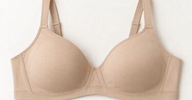 Illustration of plain beige full-coverage bra with adjustable straps laid flat on an ivory surface