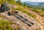 Illustration of two unbranded cork-grip trekking poles resting on a rock beside a daypack and trail